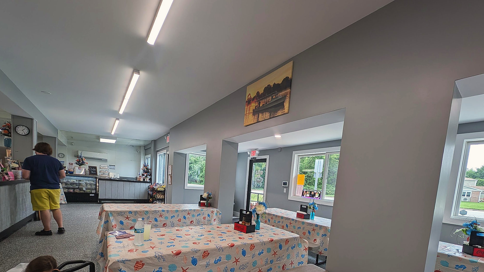 The dining room: tables under crab-print cloths, the counter and the bakery case at the back